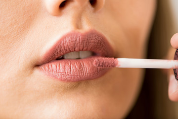 Woman putting lipstick on