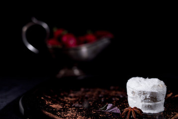 White icecream with chocolate and strawberry on the black background