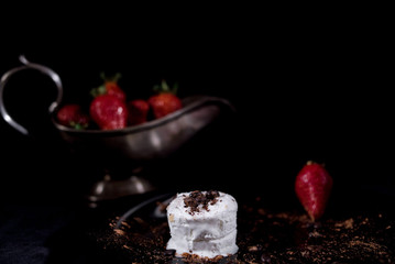 White icecream with chocolate and strawberry on the black background