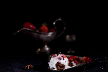 White icecream with chocolate and strawberry on the black background