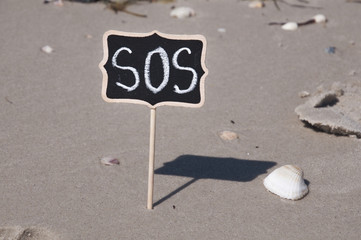  wooden plaque on the beach with an inscription