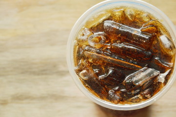 cola with ice in plastic cup