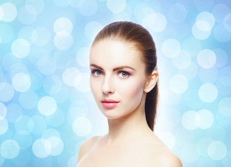 Naklejka premium Portrait of young, beautiful and healthy woman: over blue blurry background. Healthcare, spa, makeup and face lifting concept.