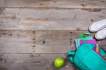 Backpack with school stationery on wooden background