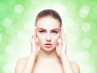 Portrait of young, beautiful and healthy woman: over green background. Healthcare, spa, makeup and face lifting concept.