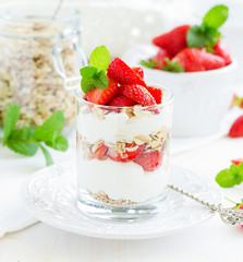 Dessert in a glass with granola, yogurt and strawberries. Useful breakfast.