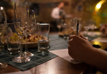 Wine tasting sommelier writes something in note table.