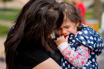 A little girl is crying in her arms. Mothers Day.