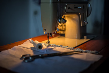 Sewing machine, sewing process, scissors and thread next to machines, pause to replace the thread, fabric is stitched