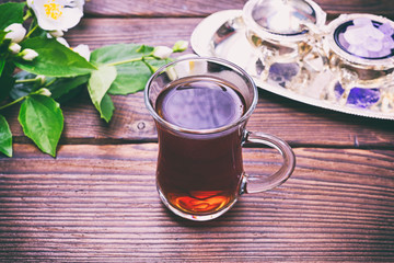 Black tea in a glass transparent glass with a handle