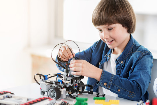 Happy smiling boy constructs technical toy