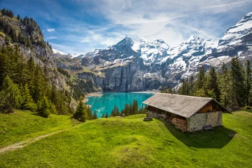 Fototapete Alpen Erstaunlicher Tourquise Oeschinnensee mit Wasserfällen, Holzchalet und Schweizer Alpen, Berner Oberland, Schweiz.