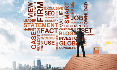 Young businessman standing on house roof and writing leadership skill concept. Mixed media