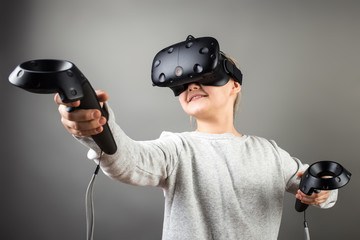 The beautifull young girl playing games with virtual reality goggles at the office