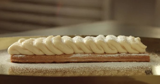 caramelizing a shugar on cream on puff pastry cake with kitchen blowtorch