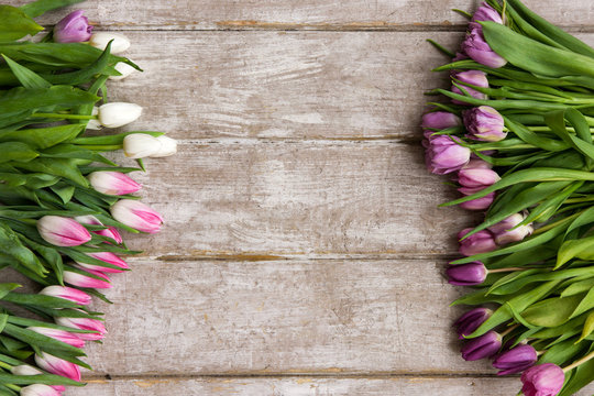 Frame of pink tulips. Floral background. Spring flower bouquet on wooden backdrop with copyspace. Wedding, gift, birthday, 8 march, mother's day greeting card concept