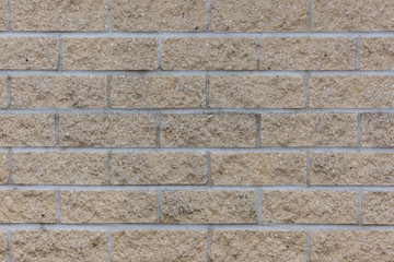 Mauer mit gelben Ziegelsteinen und weißen Fugen als Hintergrund