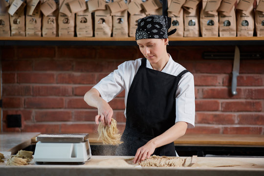 Woman cooking noodles in cafe