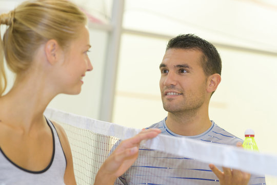 Man and woman looking at eachother over badminton net