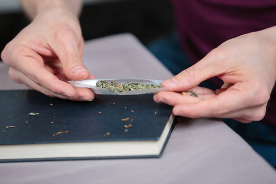 Hands preparaing a cannabis cigarette