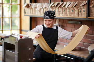 Woman rolling dough in cafe - Powered by Adobe