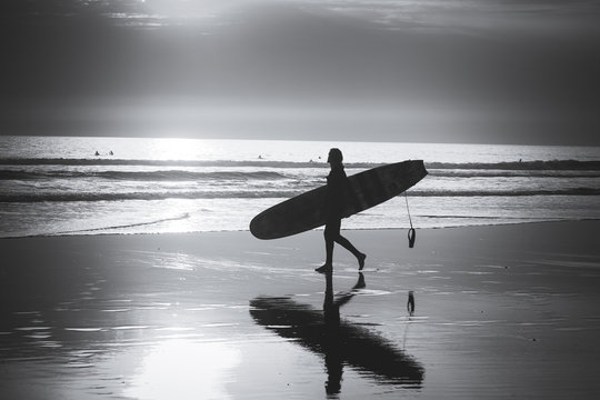 atardecer con silueta de surfero y su tabla 