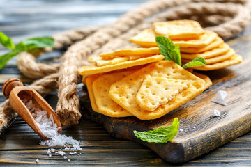 Crisp crackers and a wooden scoop with salt.