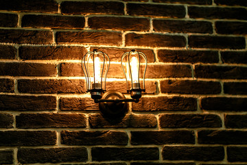 Electric bulb stylized vintage on a brick wall.