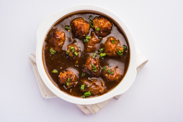 Gobi Manchurian dry or with gravy - Popular street food of India made of cauliflower florets, selective focus