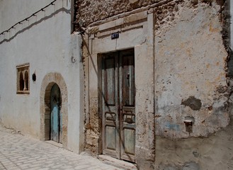 The ancient door in the street of the eastern city/ Old door in the wall in the medina of the eastern city, Tunisia