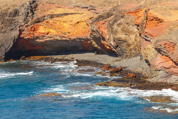 volcanic coastline with wavy ocean and blue sky, Lanzarote island, Spain