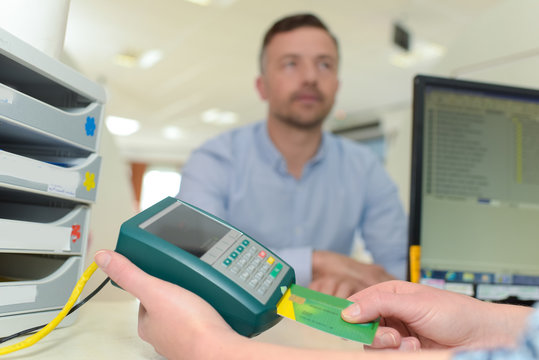 Medical woker putting health card into electronic reader