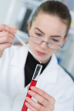 Scientist dripping liquid into test tube