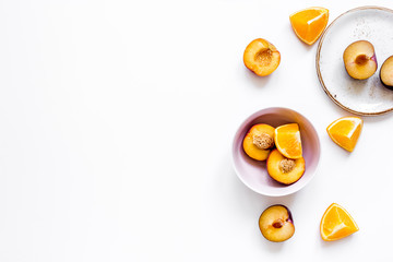 tropical fruits design with orange and peach on plate white background top view mock up
