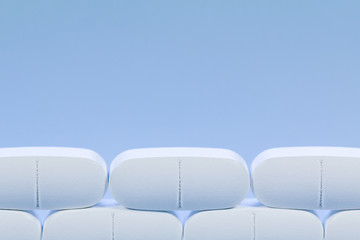 Rows of white pills on a blue background