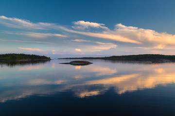 Fototapeta na wymiar Reflection of clouds to water. Evening sky. Sunset over the water. White Nights. Karelia. Ladoga lake.