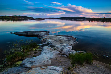 Sunset in the reflection of water. Wild nature of the north. White Nights. Karelia. Ladoga lake. Russia.