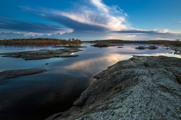 Fototapeta na wymiar Evening. The stone shore. Wild nature. Evening sunset. Karelia. Ladoga lake.