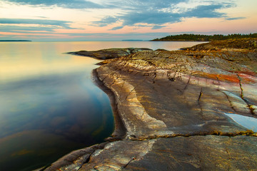 The shore is made of stone. Coastline. Morning. Calm. Karelia. Ladoga lake.
