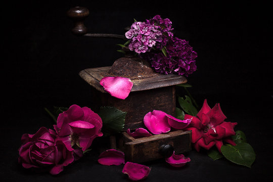 romance concept with vintage coffee greinder full of petals flowers