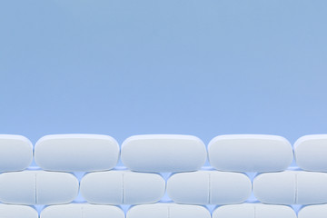 Rows of white pills on a blue background