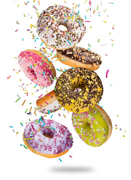 Tasty doughnuts in motion falling on white background.