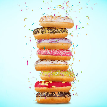Donuts glazed with sprinkles on pastel blue background.