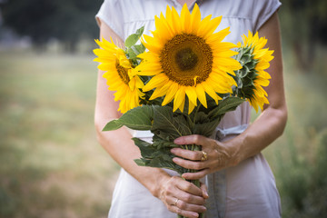 Obraz premium Girl holding sunflowers