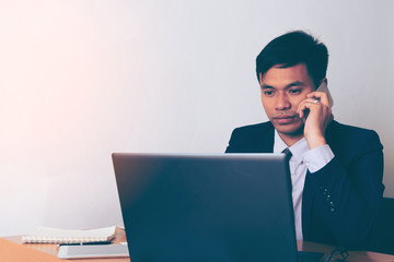 Entrepreneur working on the phone sitting in a desk at office