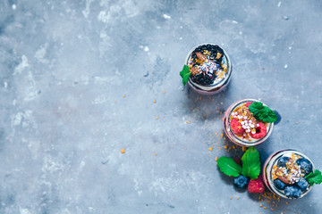 Fototapeta na wymiar Layered dessert with fruits, nuts and cream cheese in glass jar