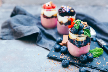 Layered dessert with fruits, nuts and cream cheese in glass jar