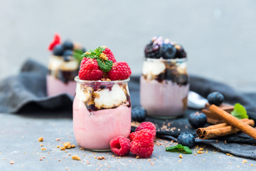 Assortment of creamy gourmet strawberry desserts layered in decorative patterns in individual glass containers
