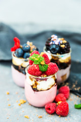 Assortment of creamy gourmet strawberry desserts layered in decorative patterns in individual glass containers