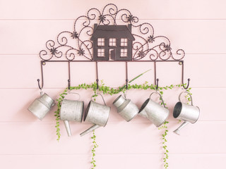 Watering can be decorated on the side of the house.